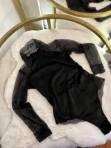 Body negro de terciopelo con mangas largas de tul y detalles de encaje en puños y parte inferior.