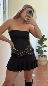 Vestido corto negro sin mangas, confeccionado en jersey de lycra con delantera doble.