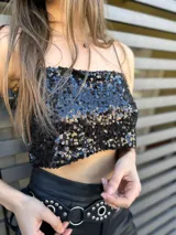 Top corto negro con lentejuelas y tirantes finos.