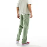 Pantalón cargo verde de corte relajado, hecho 100% de algodón, con bolsillos funcionales.