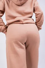 Pantalón de jogging color beige con cintura elástica y logo bordado en la pierna.