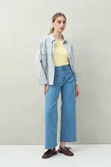 Pantalón de jean azul oscuro, de corte ancho y tiro alto, con bolsillos delanteros cuadrados y amplios.