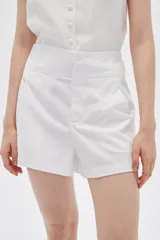 Short blanco de lino, de tiro alto y corte holgado.