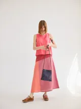 Falda midi de algodón con paneles de diferentes colores en tonos rosados y rojizos.