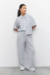 Pantalón pijama a rayas verticales azules y blancas, con cordón ajustable en la cintura.