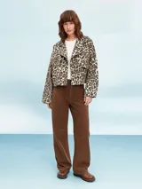 Campera color marrón claro con cuello solapa, cierre frontal con botones y bolsillos con solapa en el pecho.