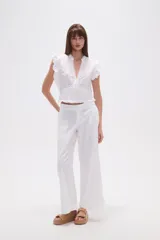 Top blanco de manga corta con escote en V, detalles bordados de hojas y puntos, pinzas, punto smock en la cintura y volados en los hombros.