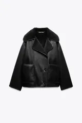 Cazadora negra de cuero sintético con cuello solapa y manga larga. Tiene bolsillos de plastrón en delantero, interior de borreguillo combinado a tono y cierre frontal con botones.