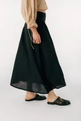 Falda midi negra de lino italiano, de corte evasé y cintura alta.