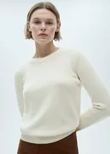 Sweater color crema de tejido de punto grueso con cuello redondo y mangas largas.