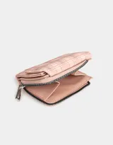 Billetera de cuerina color rosa con estampado escocés, solapa con broche y tag metálico.