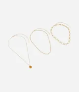 Set de tres collares dorados de diferentes largos y diseños. Incluye un collar con colgante circular de resina color ámbar, un collar de cadena fina y un collar de cadena gruesa con eslabones ovalados.