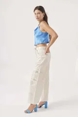 Blusa celeste de satén con breteles finos y escote drapeado.