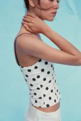 Top blanco con estampado de lunares marrones, corte corsetero, escote corazón y tirantes finos ajustables.