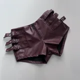 Short de cuero sintético color borgoña, con cierre frontal y múltiples correas con hebillas metálicas.