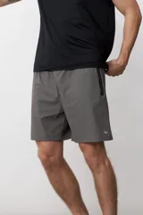 Short deportivo gris con cintura elástica, bolsillos laterales con cierre y logo estampado en la pierna derecha.