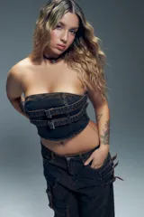 Top strapless de jean negro con hebillas metálicas ajustables y cierre en la espalda.