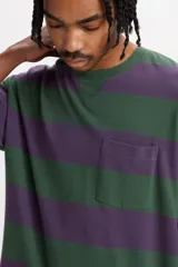 Remera de manga corta a rayas horizontales verdes y violetas, con cuello redondo y bolsillo en el pecho.