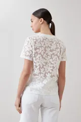 Blusa blanca de encaje con mangas cortas y cuello redondo.
