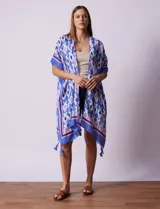 Kimono tejido color naranja con estampado geométrico en blanco y celeste, y terminación con borlas.