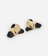 Maxi aros con forma de orquídea, confeccionados en metal dorado con detalle esmaltado en negro.