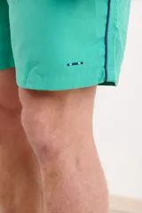 Short de baño azul marino con cintura elástica y cordón ajustable. Detalle de ribete blanco en el lateral.