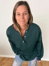 Remera verde con botones en el escote, de manga larga y corte recto.