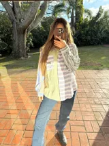 Camisa de manga larga con diseño patchwork a rayas horizontales en tonos celeste, naranja y verde. Tiene cuello clásico, bolsillo en el pecho y cierre con botones.