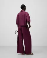 Pantalón de mujer de algodón orgánico color borgoña, con cierre de botón, cinturilla elástica en la espalda, doble pinza en el delantero, bolsillos laterales y pierna ancha.