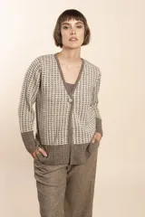 Cardigan tejido con efecto fantasia color crema. Una prenda de silueta amplia y cómoda. Tejido en 100% lana fina sin teñir.