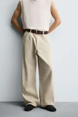 Pantalón de jean blanco, corte holgado y amplio en toda la pierna, tiro medio, tejido ligero, cinco bolsillos, efecto lavado y cierre frontal con cremallera y botón.