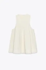 Vestido corto color crema con escote en V y sisas anchas. Tiene forro interior combinado a tono.