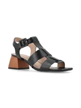 Sandalias negras de cuero con tiras entrecruzadas y hebilla lateral. Taco de madera geométrico.