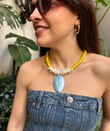 Collar corto de cristales amarillos y nácar blanco con dije de nácar celeste en forma ovalada.