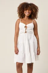 Vestido corto color verde claro, con tirantes finos, detalle de lazo en el escote y falda con volantes escalonados.