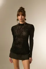 Top de manga larga ajustado al cuerpo, con cuello alto y estampado de leopardo en negro. El tejido es transparente con el patrón en relieve.