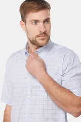 Camisa celeste y blanca a cuadros de manga corta con bolsillo en el pecho y logo bordado.