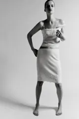 Top de punto color crema claro, corte recto y ajustado, con detalle de encaje floral bordado en el escote. Posee tirantes ajustables de color beige claro.