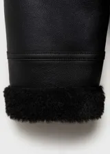 Chaqueta biker negra de efecto piel con cuello de borreguito, cierre de cremallera asimétrico, bolsillos laterales con cremallera y terminaciones de borreguito.