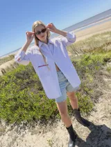 Camisa oversize a rayas verticales azules y blancas, con bolsillo en el pecho con detalle bordado.