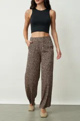 Pantalón largo de corte recto con estampado animal print en tonos beige y negro. Tiene bolsillos laterales y cintura elástica.