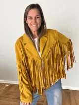 Campera de gamuza sintética color mostaza con flecos largos en mangas y espalda, corte recto con solapas clásicas.