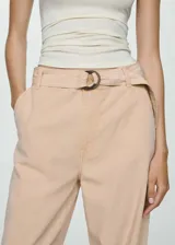 Pantalón color beige de corte wide leg, tiro medio y cinturón ajustable con hebilla circular.