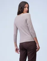 Buzo de tejido fino, color beige, con mangas tres cuartos estilo raglán.