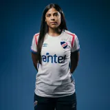 Camiseta de fútbol Umbro del Club Nacional de Football, modelo Home 2025, para mujer. Diseño blanco con detalles en azul y rojo en cuello y mangas. Incluye logo de Umbro, escudo del club y sponsor Antel en el frente.