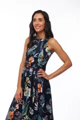 Vestido midi con estampado floral multicolor sobre fondo azul marino, sin mangas, con cuello redondo y cinturón a juego.