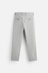 Pantalón slim fit negro confeccionado en tejido con elasticidad en ambas direcciones. Cuenta con bolsillos frontales y traseros de vivo con botón. Cierre frontal con cremallera y botón.