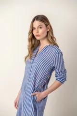 Vestido largo camisero a rayas verticales azules y blancas, con cuello mao, abotonadura frontal completa, mangas largas y bolsillos laterales.