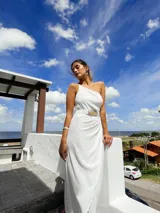 Vestido largo blanco de crepé, con breteles finos, falda irregular en capas y cinturón anudado con aplique de alpaca y ágata.