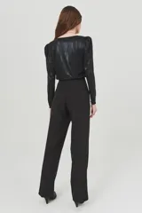 Pantalón negro de vestir, de corte palazzo y tiro alto, con bolsillos laterales.